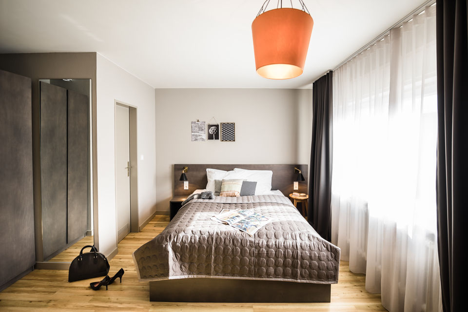 Serviced apartment, bedroom with orange pendant light in Frankfurt Gallus