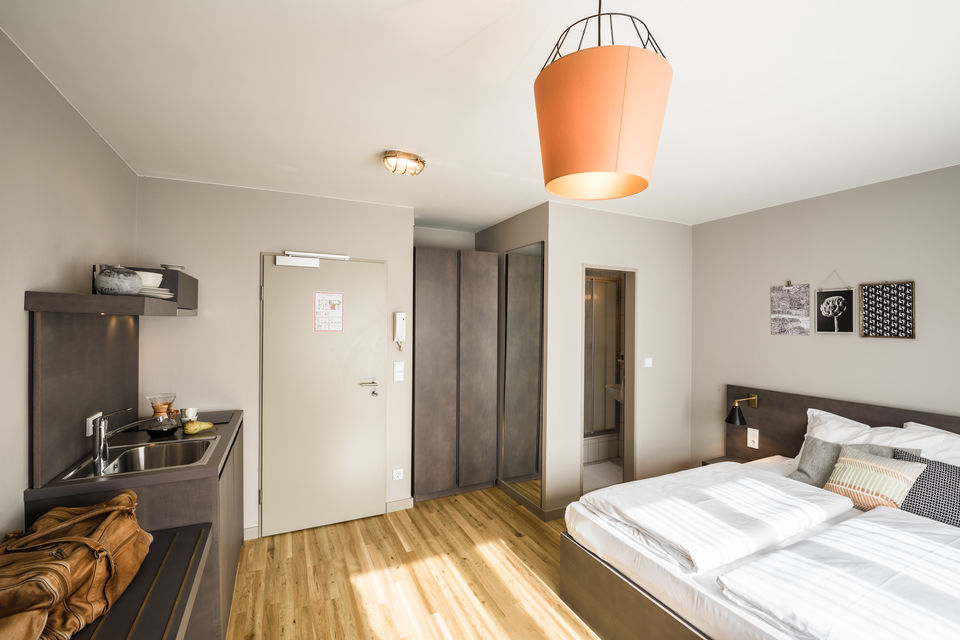 Serviced apartment, bedroom with orange pendant light in Frankfurt Gallus