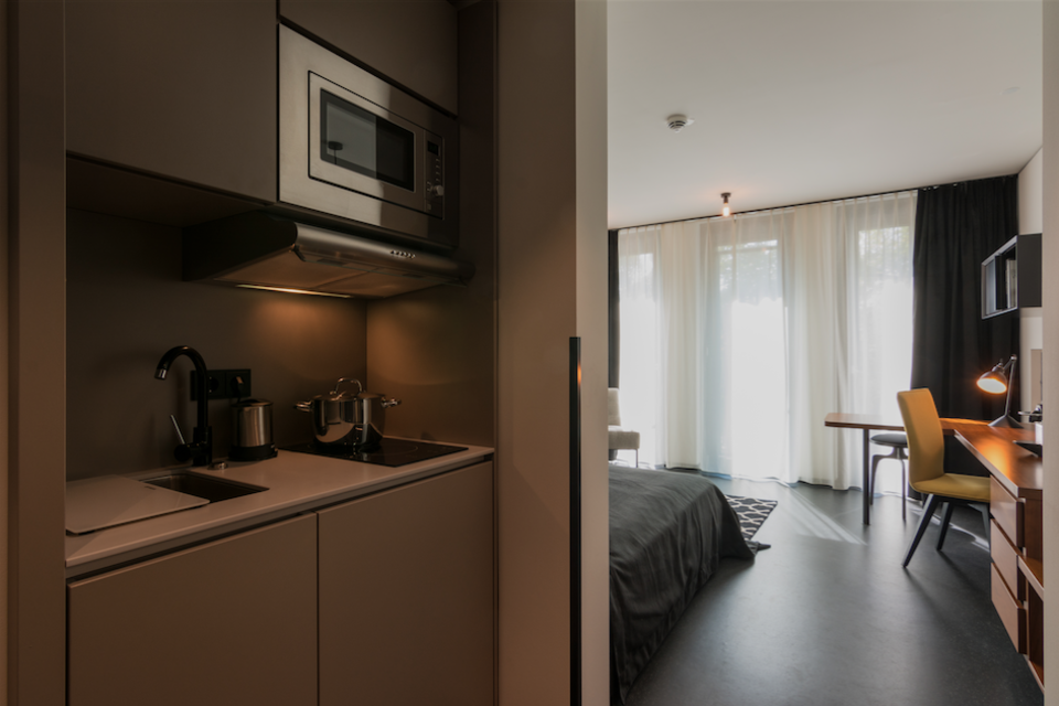 Serviced Apartment, Schlafzimmer mit offener Küchenzeile in München Schwabing