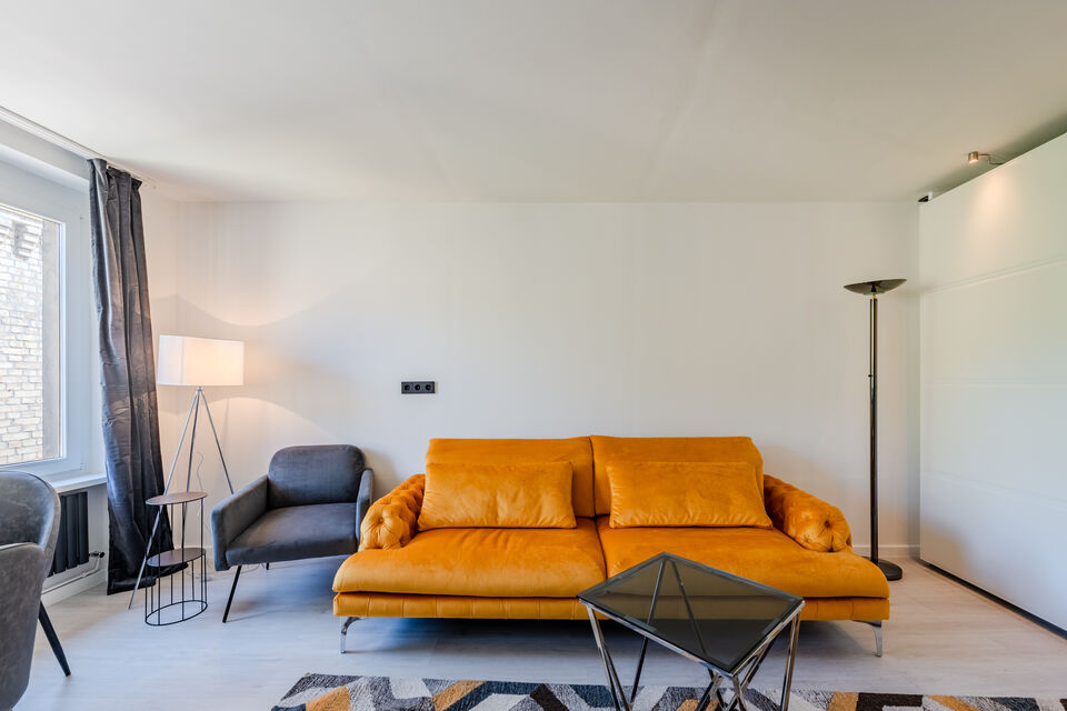 Furnished apartment, living room with orange sofa in Berlin Kreuzberg