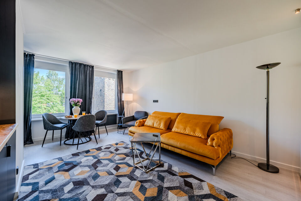 Furnished apartment, living room with yellow velvet sofa in Berlin Kreuzberg