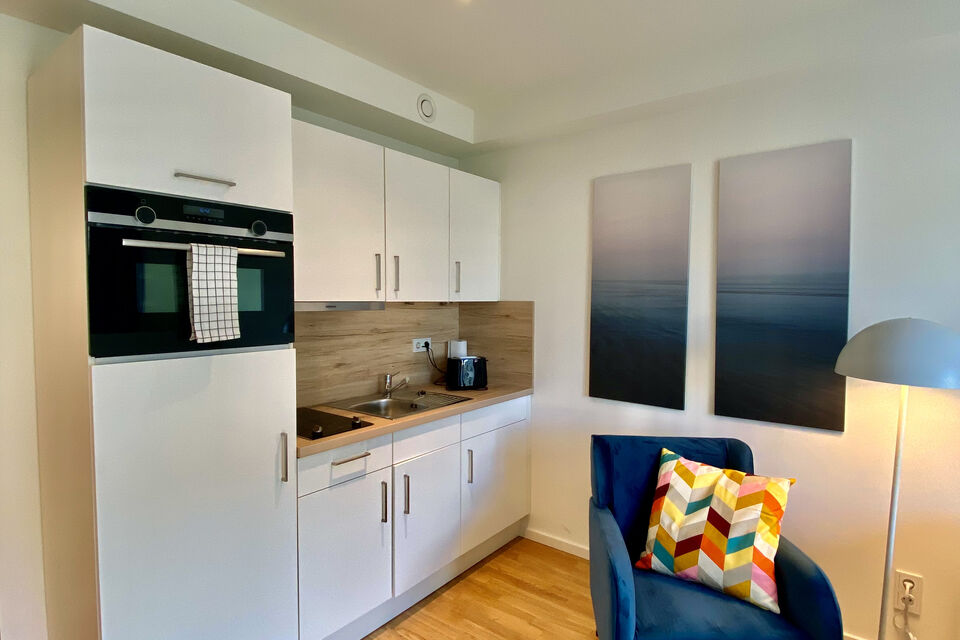 Furnished apartment, kitchen with white cabinetry and wooden worktop in Berlin Mitte