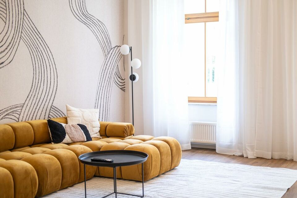 Möblierte Wohnung, Wohnzimmer mit geschwungenem Sofa in Berlin Mitte