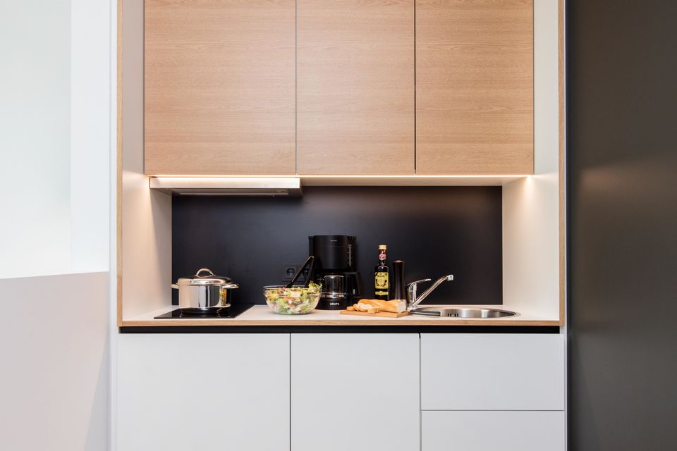 Serviced apartment, kitchen with black backsplash in Berlin Charlottenburg