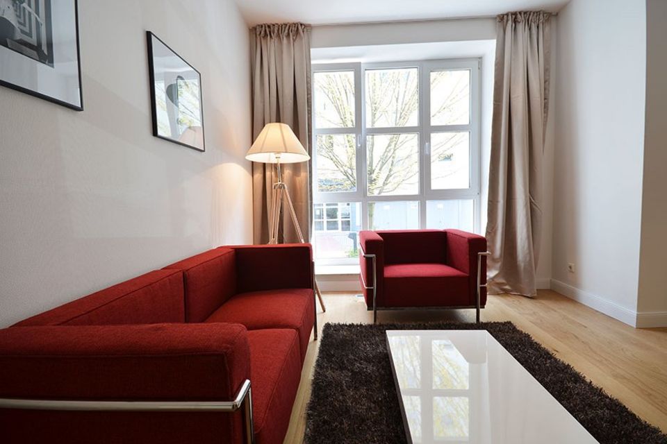Möblierte Wohnung, Wohnzimmer mit rotem Designsofa in Frankfurt Sachsenhausen