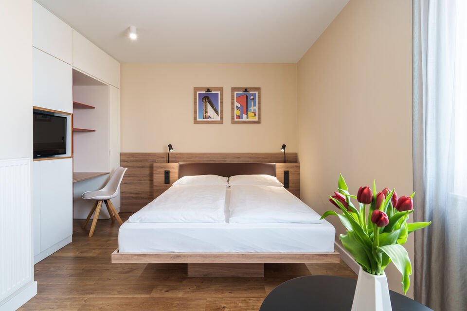 Serviced apartment, bedroom with wooden bed in Berlin Prenzlauer Berg