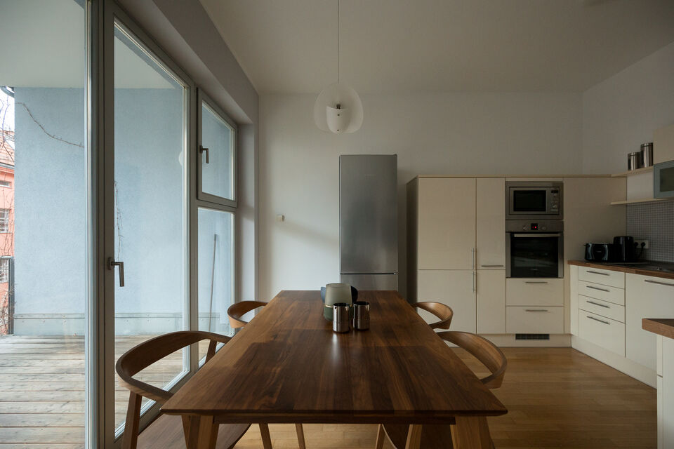 Apartment, dining area & kitchen with wooden table and balcony access in Berlin Mitte