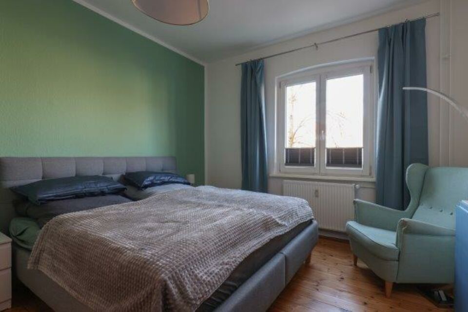 Möblierte Wohnung, Schlafzimmer mit grüner Akzentwand in Berlin Prenzlauer Berg