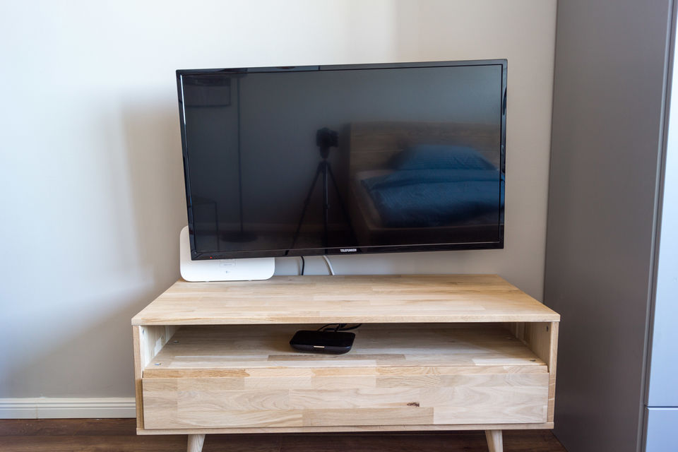 Furnished apartment, living room with wooden dresser and flat-screen TV in Berlin Mitte