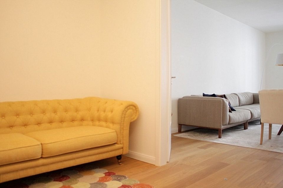 Furnished apartment, living room with yellow Chesterfield sofa in Berlin Mitte