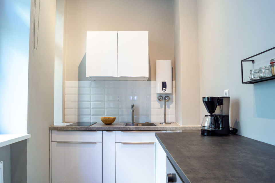 Furnished apartment, kitchen with white cabinetry in Berlin Friedrichshain