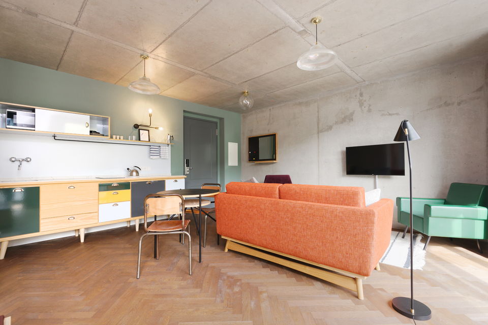 Serviced apartment, living room with orange sofa in Berlin Mitte