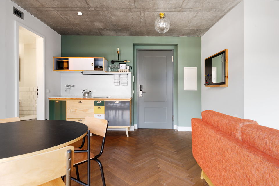 Serviced apartment, living room with orange sofa in Berlin Mitte