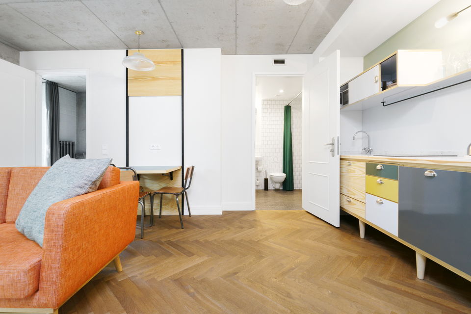 Serviced apartment, living room with orange sofa in Berlin Mitte