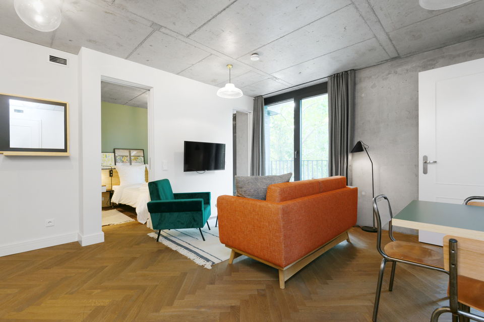 Serviced apartment, living room with orange sofa in Berlin Mitte