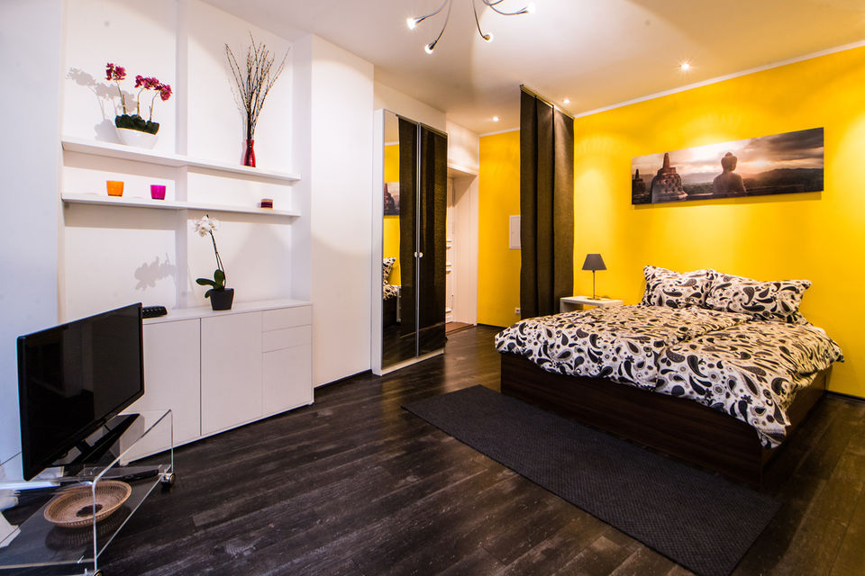 Furnished apartment, bedroom with yellow accent wall in Berlin Mitte