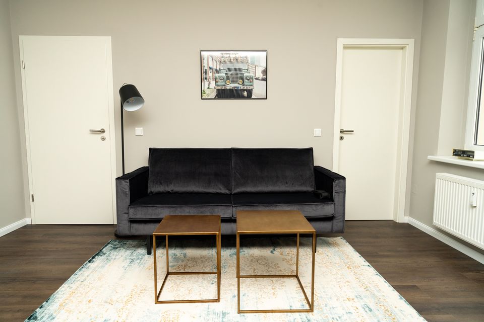 Furnished apartment, living room with black velvet sofa in Berlin Friedrichshain