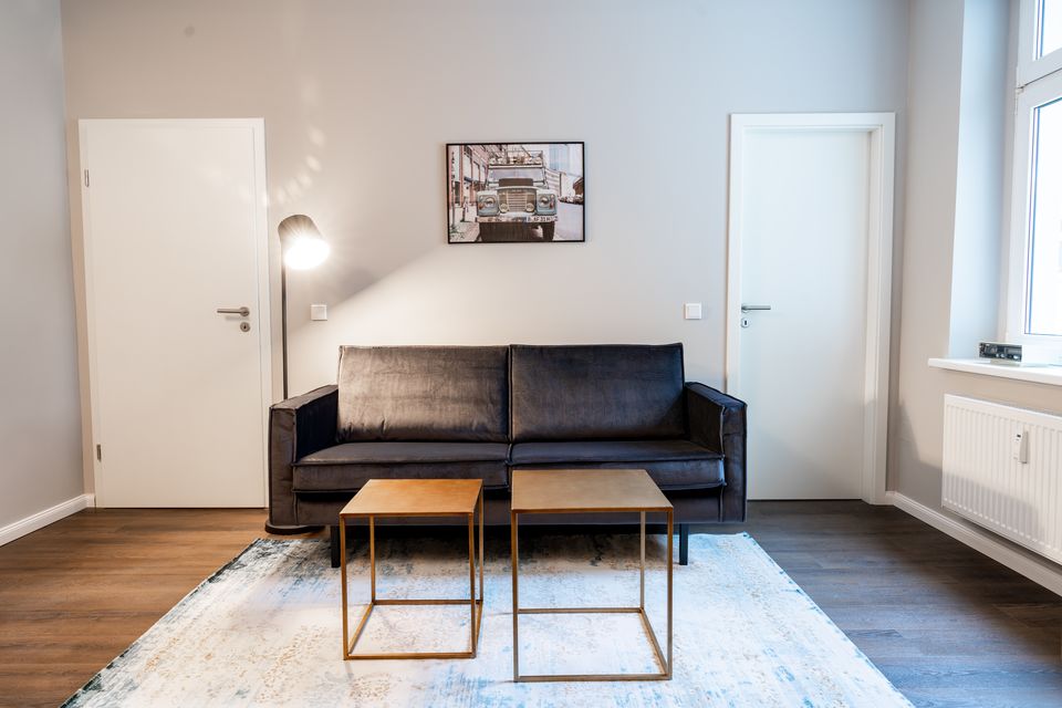 Furnished apartment, living room with black leather sofa in Berlin Friedrichshain