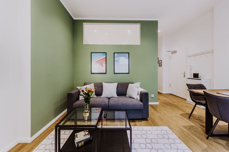 Furnished apartment, living room with green accent wall in Berlin Mitte