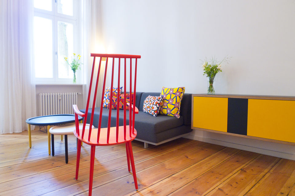Möblierte Wohnung, Wohnzimmer mit rotem Designerstuhl in Berlin Kreuzberg