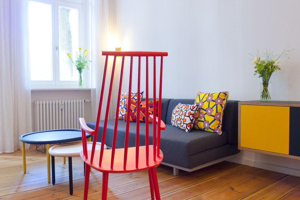 Möblierte Wohnung, Wohnzimmer mit rotem Designerstuhl in Berlin Kreuzberg