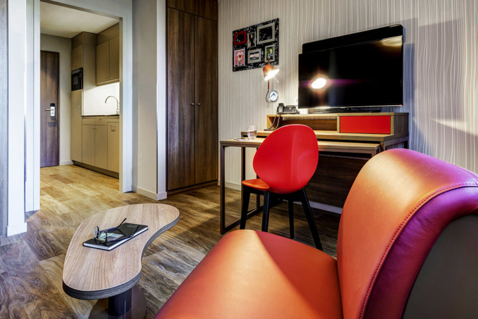 Serviced Apartment, Wohnzimmer mit rotem Designsessel in Frankfurt Innenstadt