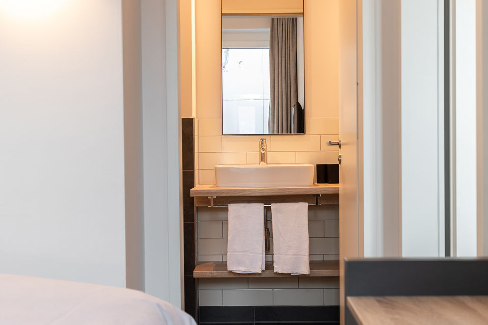 Serviced Apartment, Ensuite-Bad mit Waschtisch und Spiegel in Hamburg Stellingen