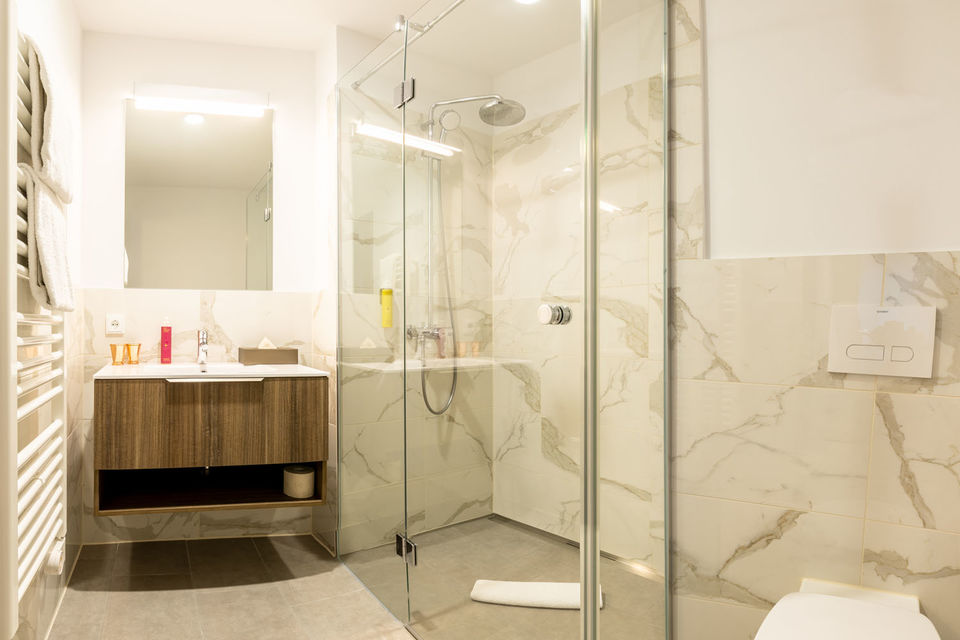 Serviced Apartment, Badezimmer 1 mit Marmor-Dusche in München Trudering