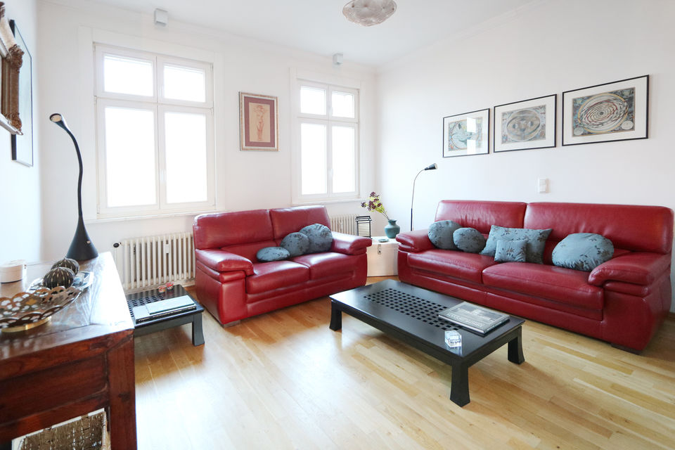 Furnished apartment, living room with red leather sofas in Berlin Friedrichshain