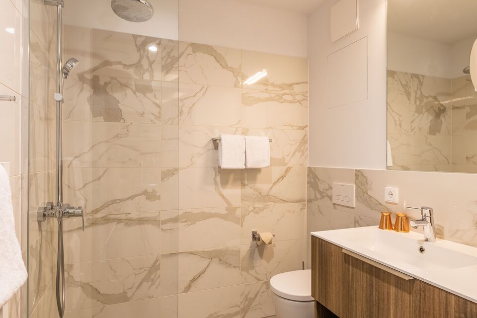Serviced apartment, Bathroom 1 with marble wall cladding in München Aschheim-Dornach