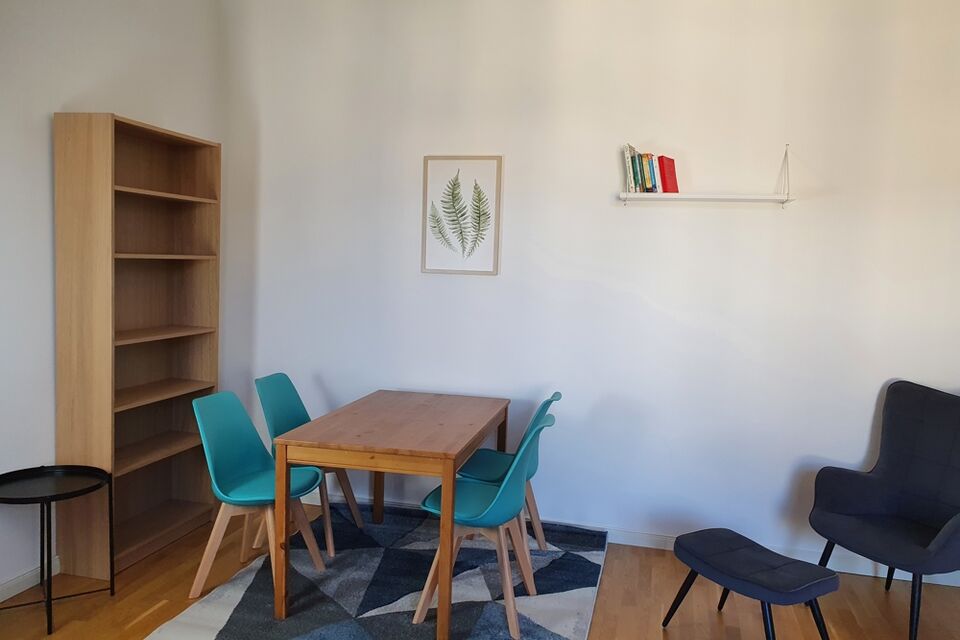 Furnished apartment, dining room with wooden table and turquoise chairs in Berlin Schöneberg
