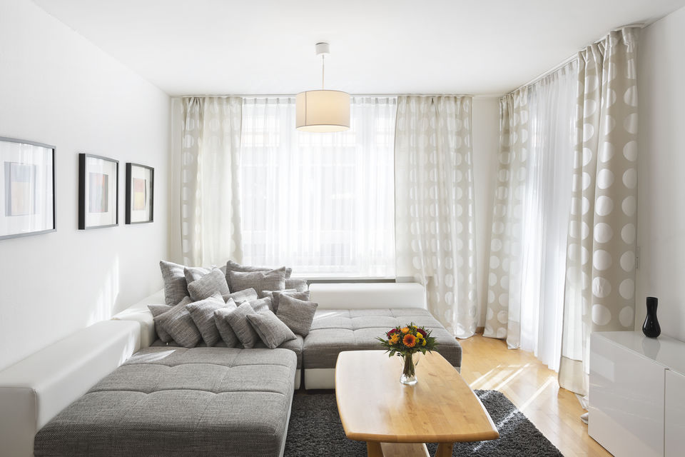 Serviced Apartment, Wohnzimmer mit Ecksofa und Panoramafenstern in Berlin Tiergarten