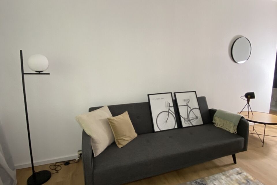 Furnished apartment, living room with black sofa in Berlin Treptow-Köpenick