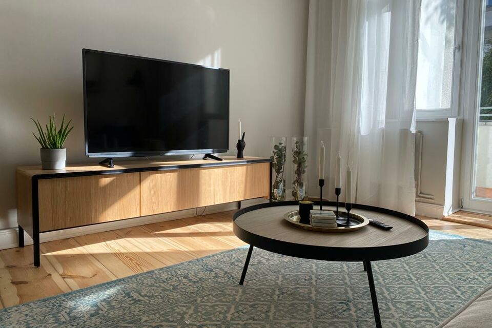 Furnished apartment, living room with modern wooden TV unit in Berlin Charlottenburg