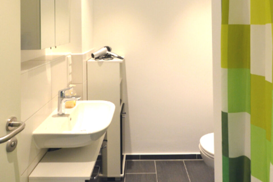 Serviced apartment, Bathroom 1 with green accent wall in Frankfurt Niederrad