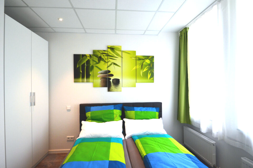 Serviced apartment, bedroom with green and blue color scheme in Frankfurt Niederrad