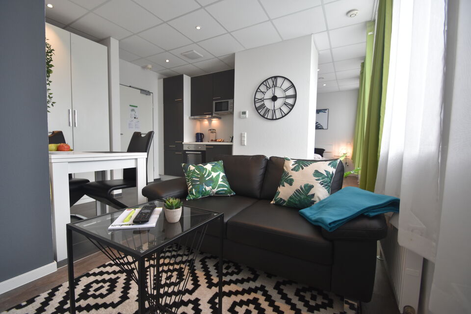 Serviced Apartment, Wohnzimmer mit schwarzem Sofa in Frankfurt Niederrad