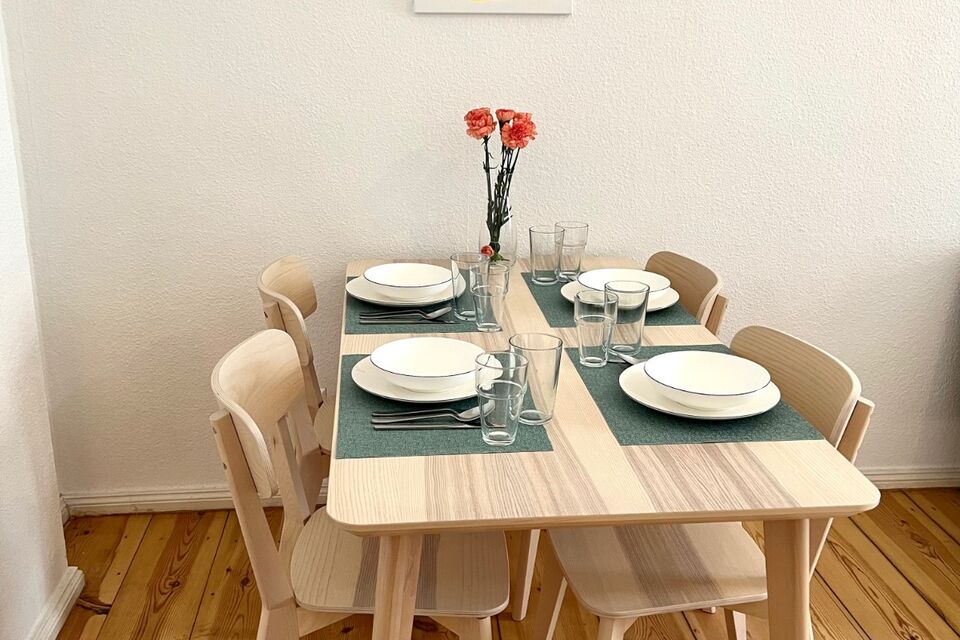 Furnished apartment, dining room with wooden table and fresh flowers in Berlin Neukölln