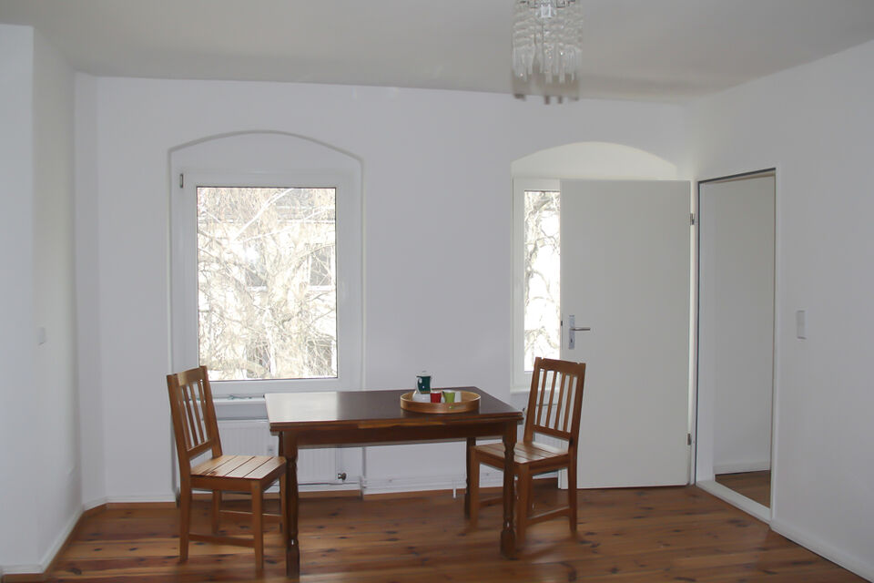Furnished apartment, dining room with wooden table and arched windows in Berlin Neukölln