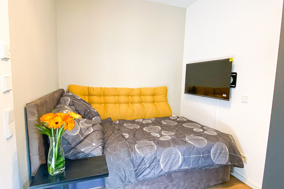 Möblierte Wohnung, Schlafzimmer mit gelbem Wandpaneel in Berlin Friedrichshain