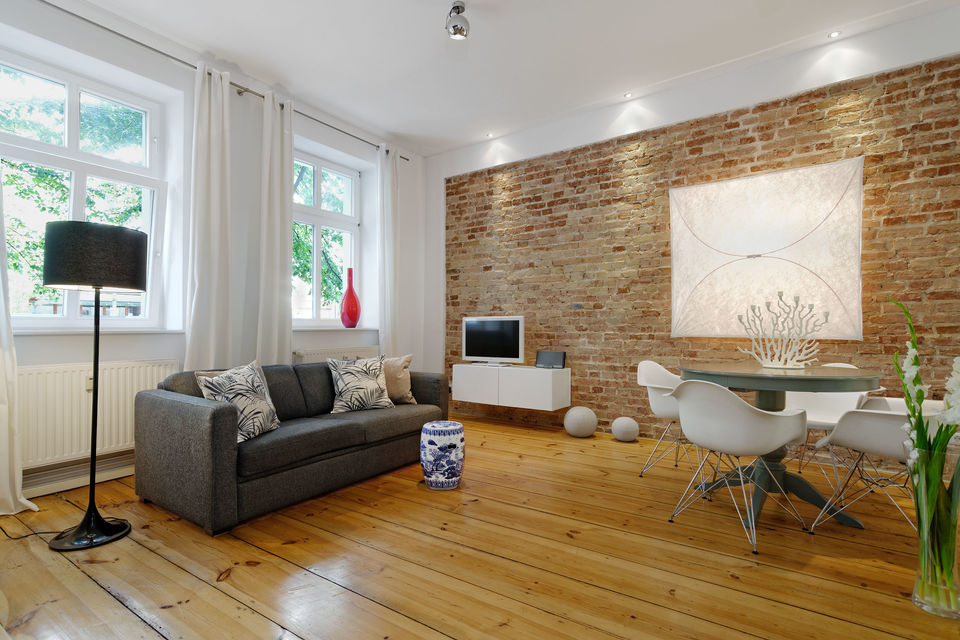 Möblierte Wohnung, Wohnzimmer mit Ziegelwand in Berlin Mitte