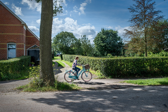 Een meisje fietst op het Groningse platteland