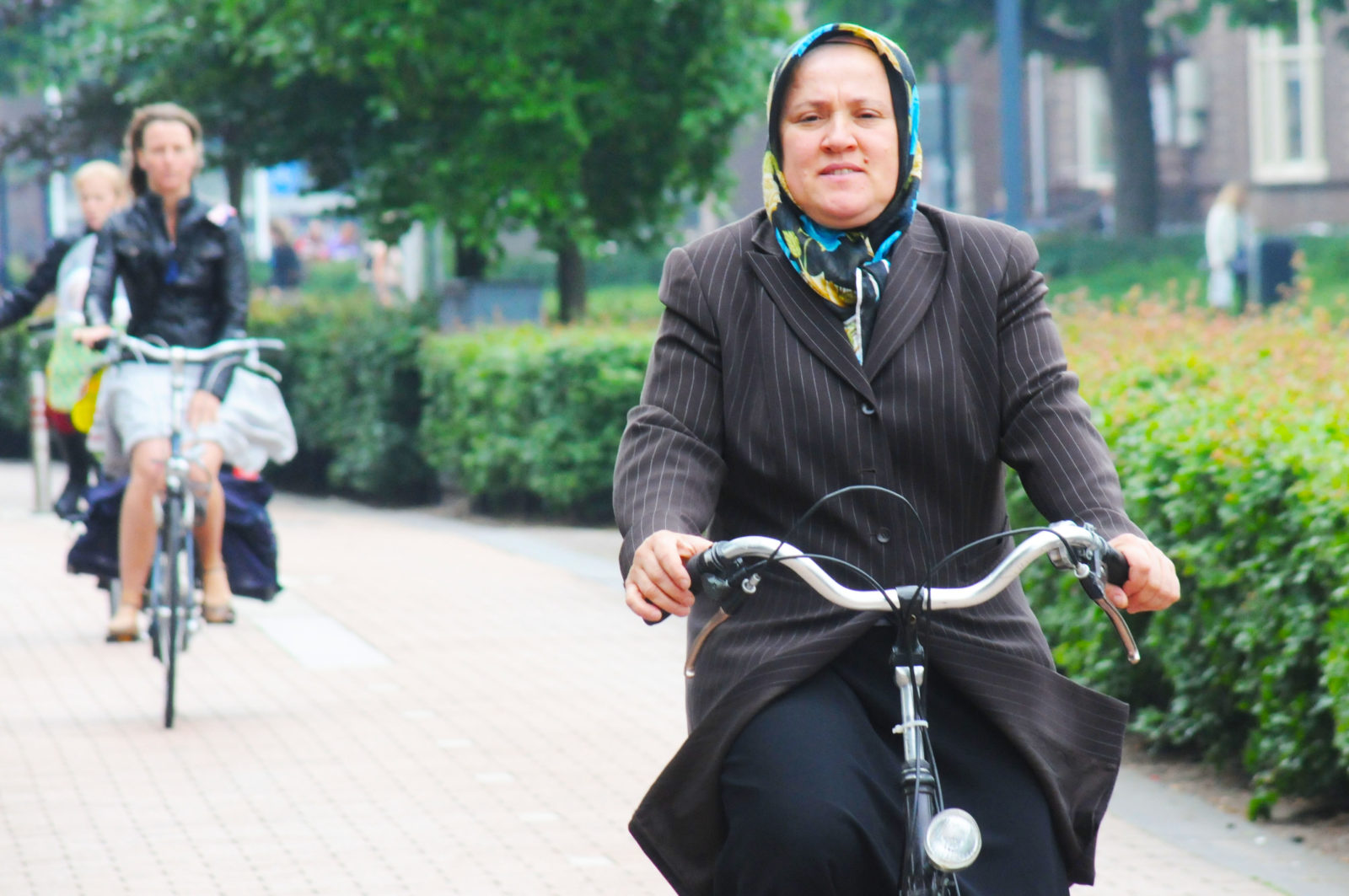 Vrouw met hoofddoek fietst in Amsterdam