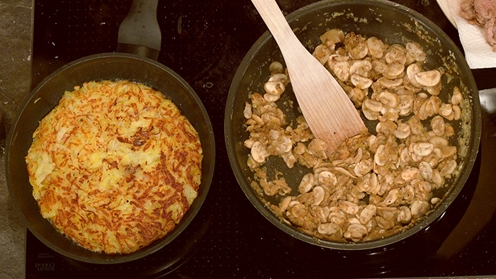 Blick auf eine Pfanne mit Rösti und eine Pfanne mit Zürcher Geschnetzeltes