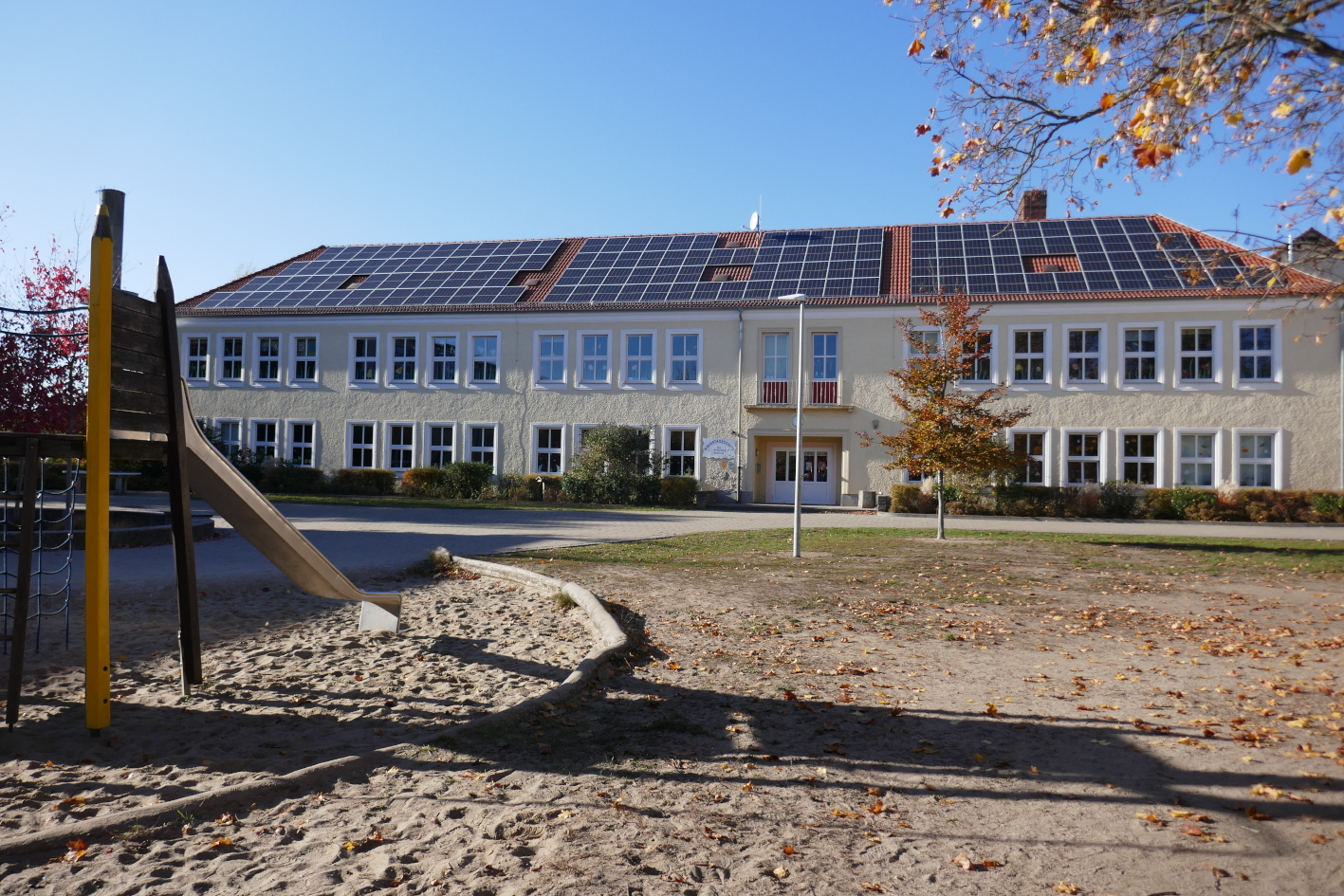 Haus mit Solaranlage, im Vordergrund links ist ein Spielplatz zu sehen. ©BEOS eG
