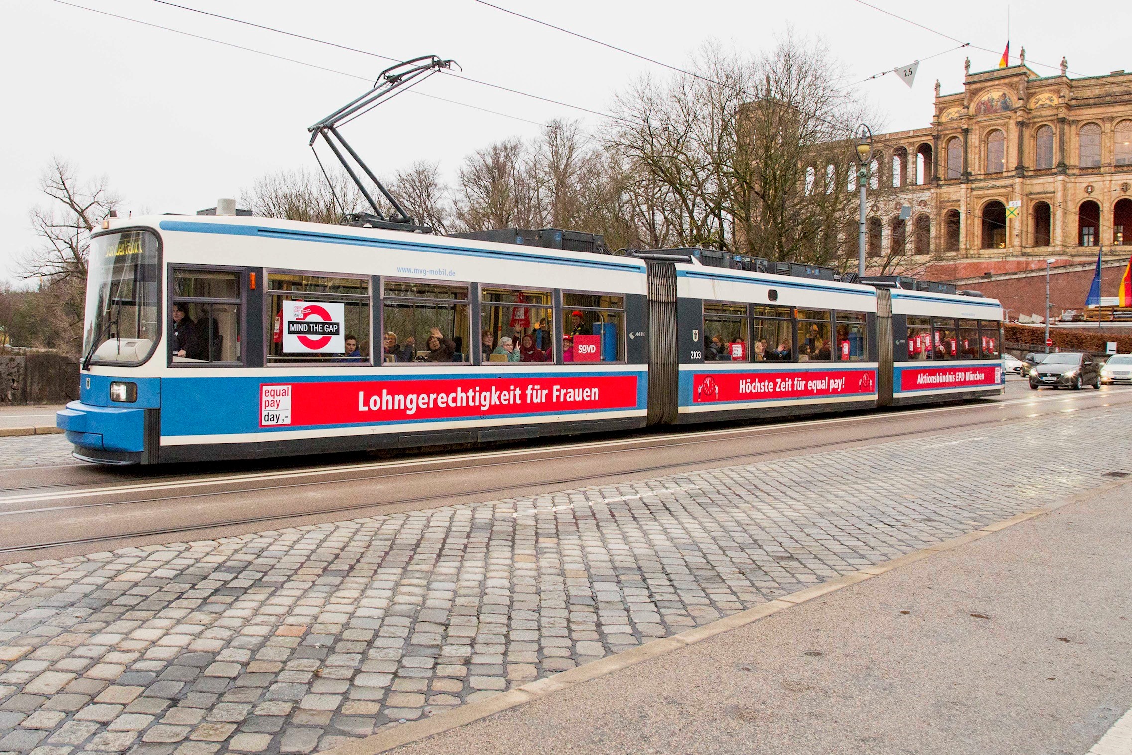 Straßenbahn mit Aufschrift "Lohngerechtigkeit für Frauen"