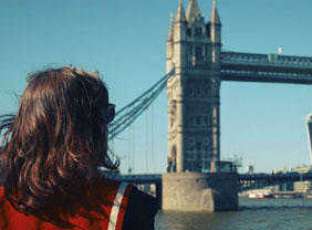 Junge Frau blickt auf die Tower Bridge in London