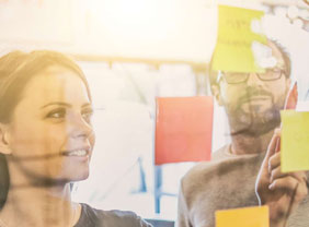 Junge Arbeitnehmer /-innen arbeiten mit Post-Its