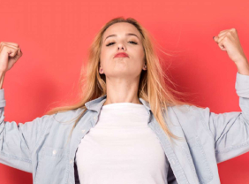 Junge Frau macht eine Gewinnerpose