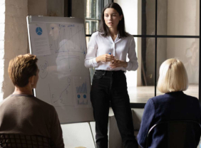 Junge Frau steht vor einer Flipchart und erklärt etwas